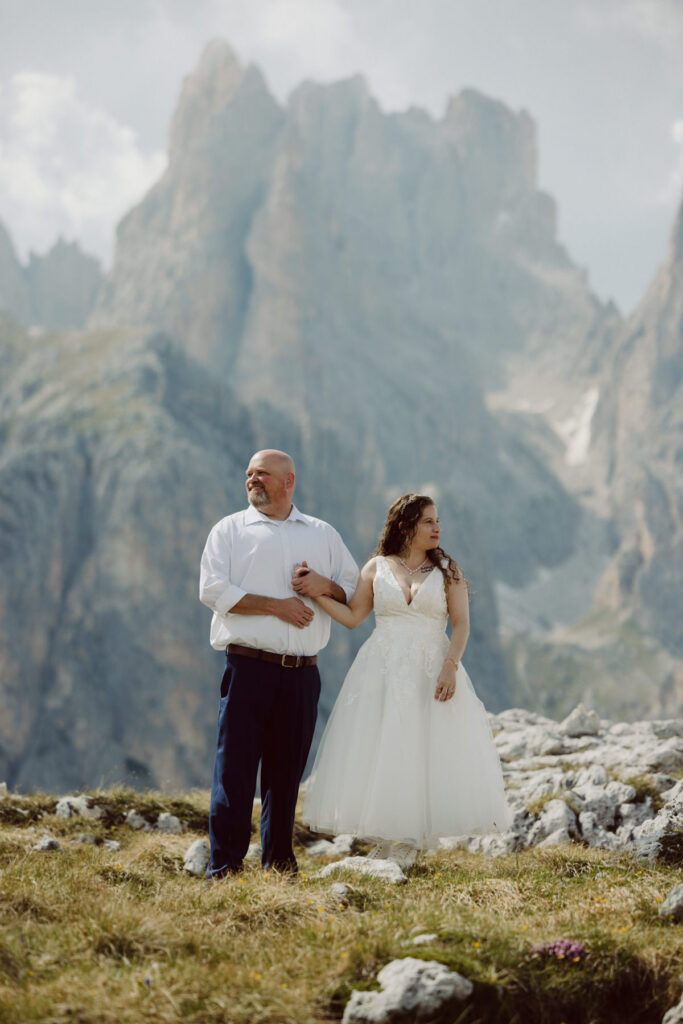 Bride and groom hiking near Tre Cime di Lavaredo during an adventurous Dolomites elopement in Northern Italy.
