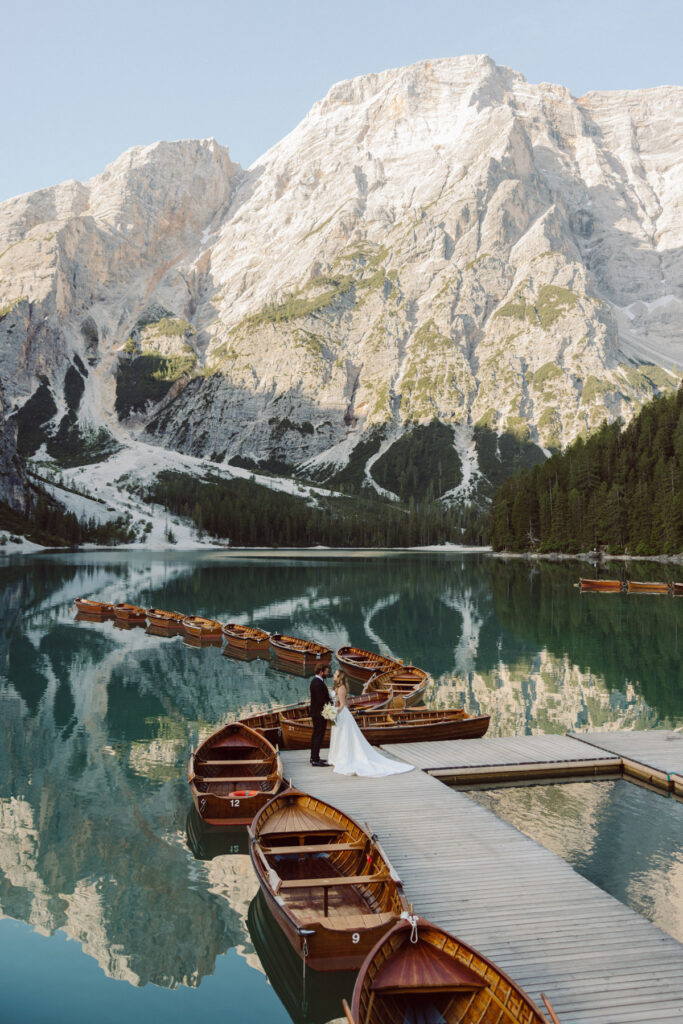 Bride and groom overlooking the turquoise waters of Lago di Sorapis during a Dolomites adventure wedding.