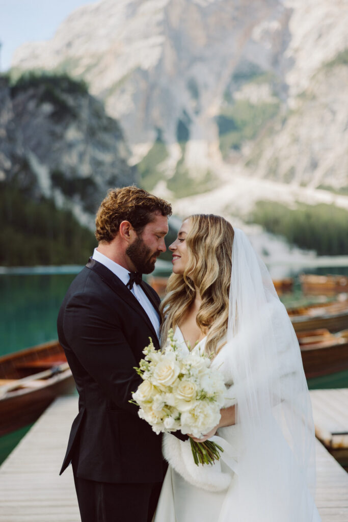 Bride and groom overlooking the turquoise waters of Lago di Sorapis during a Dolomites adventure wedding.