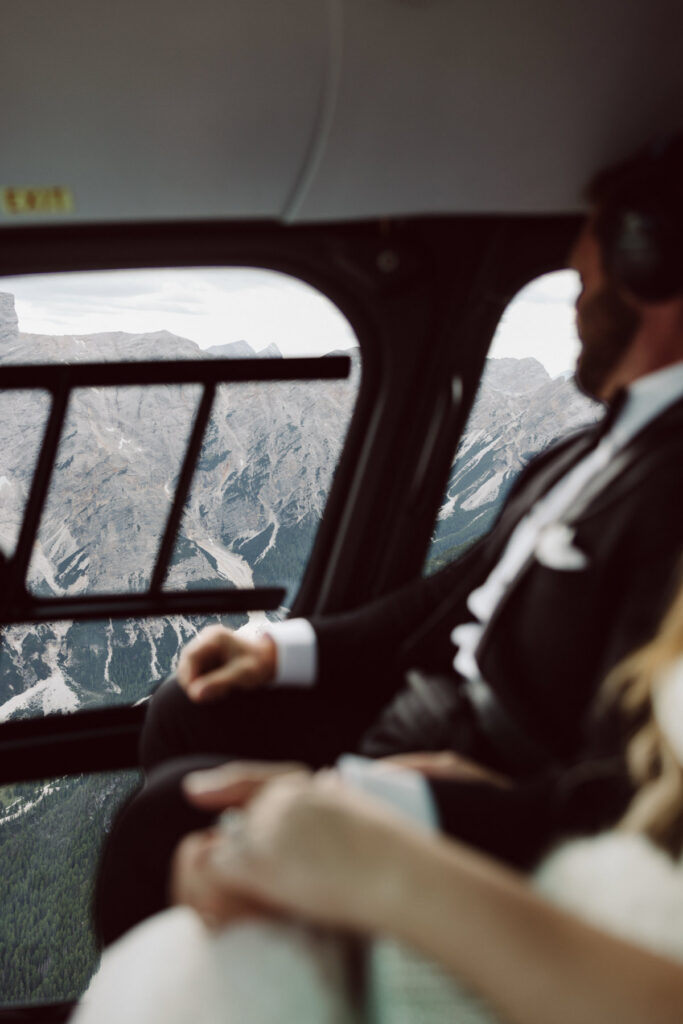 Bride and groom arriving by helicopter for an unforgettable Dolomites elopement adventure.